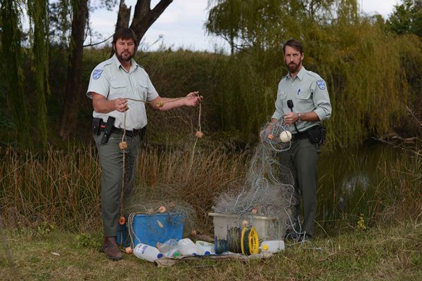 DPI fisheries officers Joe Wright (right) and Brock Mathers (left) with the seized meshing nets, set lines and drift lines